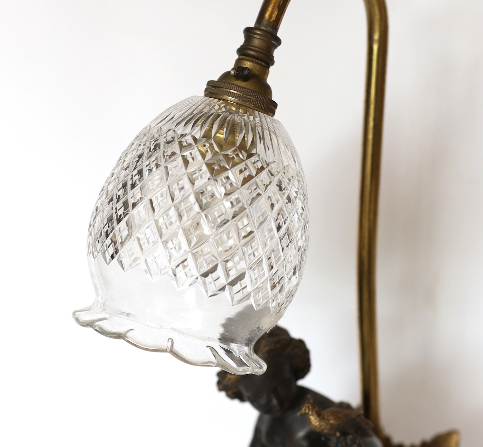 An Edwardian bronze spelter and brass table lamp with cut glass shade, height 46cm